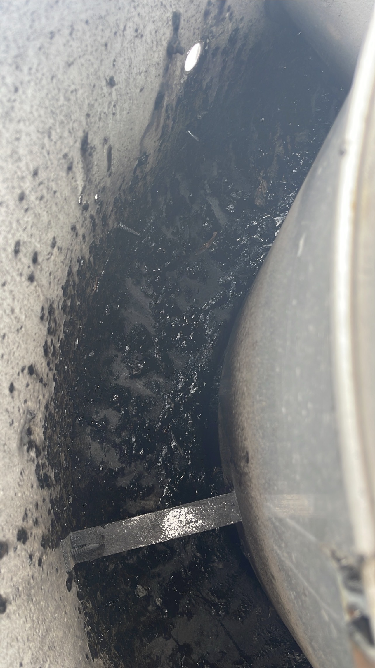 Heavy grease buildup in rooftop commercial exhaust fan before cleaning